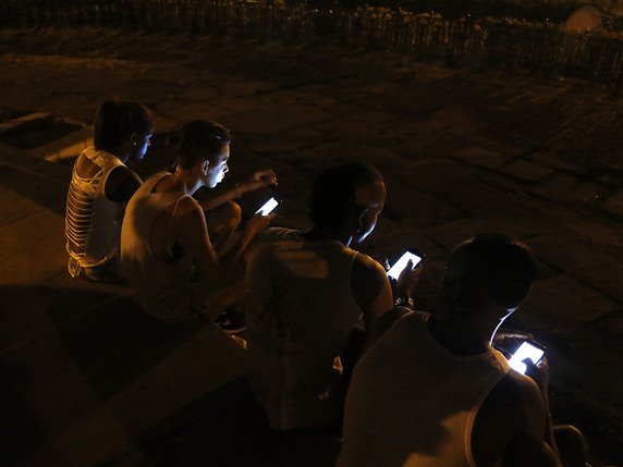 A Cuba, l'ouverture progressive d'internet au grand public engagée en 2013 n'a pas été accompagnée des baisses tarifaires attendues. Ici, des jeunes profitent du wifi d'un hôtel situé dans le centre-ville de La Havane (archives). © KEYSTONE/AP/DESMOND BOYLAN