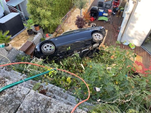 L'auto a chuté par-dessus un mur de soutènement avant de s'immobiliser à moins de 2 mètres de la façade de la maison. © Police cantonale BL