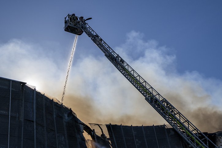 Un important incendie s'est déclaré dimanche après-midi dans la zone industrielle de Satigny (GE). Emportée par le vent, la fumée était visible de très loin. © KEYSTONE/MARTIAL TREZZINI