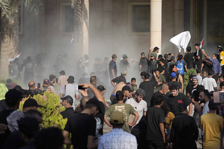 Les forces de l'ordre ont eu recours au gaz lacrymogène pour tenter de disperser les partisans de Moqtada Sadr. © KEYSTONE/AP/Hadi Mizban