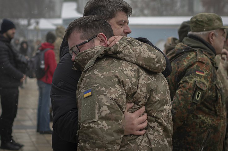 Des soldats ukrainiens pleurent la mort d'un camarade mort au combat contre l'armée russe, samedi à Kharkiv. © KEYSTONE/AP/Andrew Kravchenko