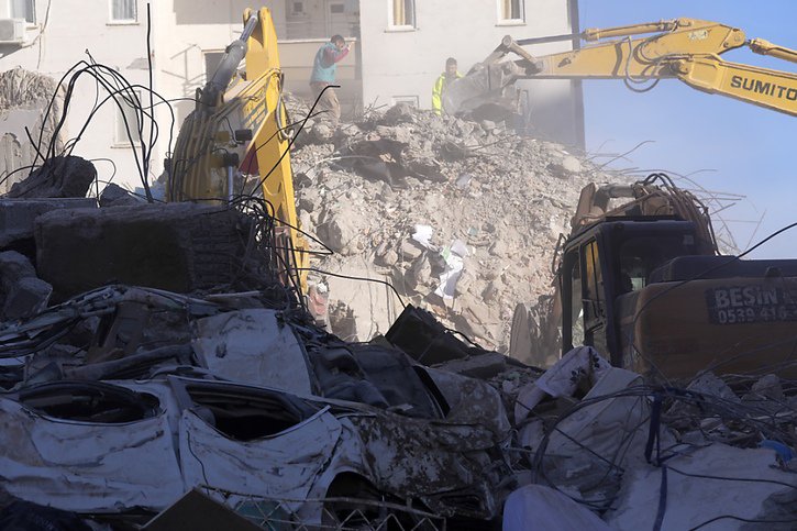 Des machines lourdes sont utilisées pour casser le béton des maisons effondrées à Adana, afin de retrouver des personnes ensevelies. © KEYSTONE/AP/Hussein Malla