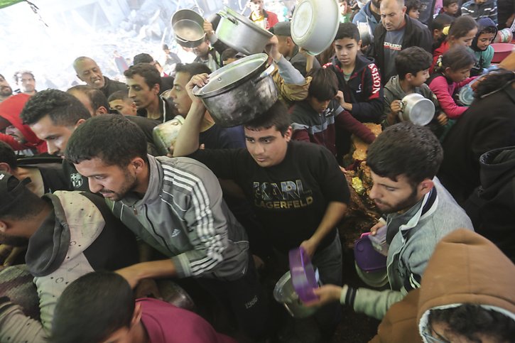 Des Palestiniens attendent de la nourriture à Rafah jeudi. Malgré son accélération, l'aide est toujours insuffisante, affirme l'ONU. © KEYSTONE/AP/Hatem Ali