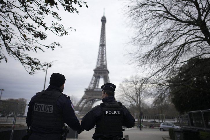 Des policiers français patrouillent dans la zone proche de la tour Eiffel où un attentat a fait un mort et deux blessés samedi. © KEYSTONE/AP/Christophe Ena