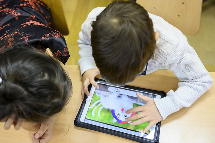 Des élèves de 4ème année primaire suivent à l'aide d'une tablette un cours d'éducation numérique. © KEYSTONE/LAURENT GILLIERON